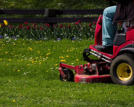 Ma mowing lawn on commercial riding mower